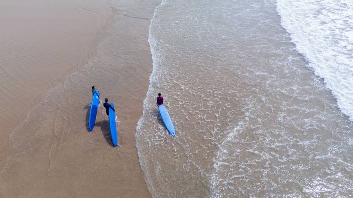 Vue aérienne d'un petit groupe au bord de l'eau avec des planches bleues