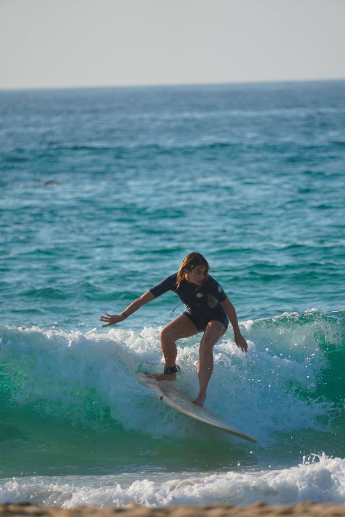 Surfeuse sur une vague turquoise